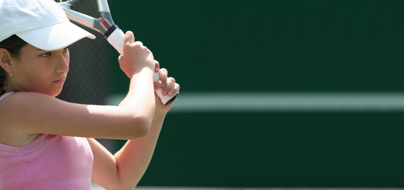 Preteen girl playing tennis